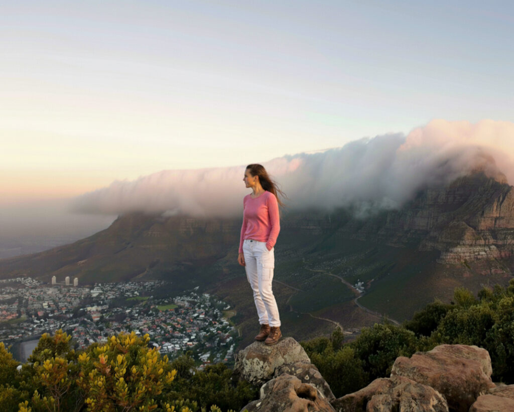 Bethany standing on the top of Lion's Head at sunset watching clouds gathering on top