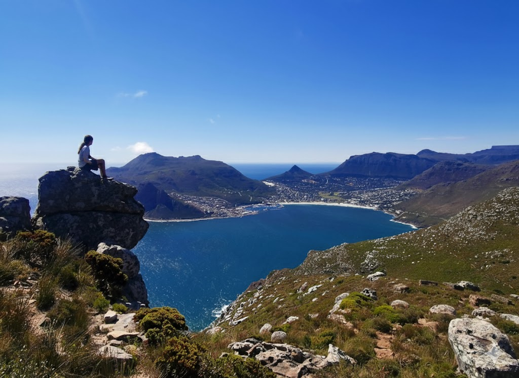 Sitting on a rock overlooking Hout Bay in Cape Town