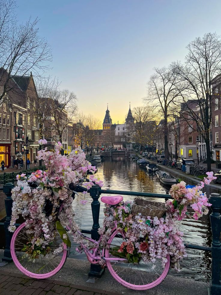 Bikes leaning on a railing next to a canal in amsterdam