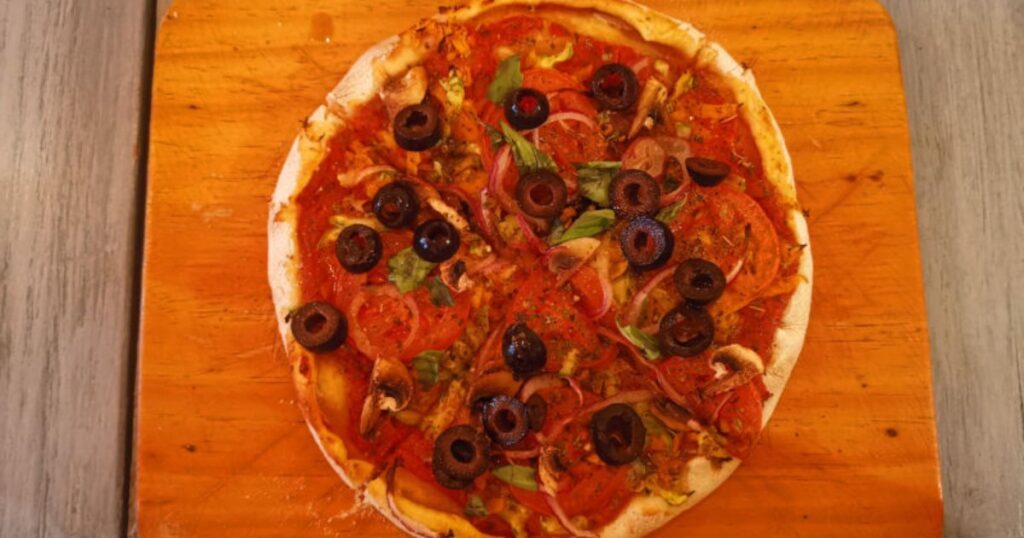 Vegetarian vegan Pizza with lots of tomatoes, basil and olives